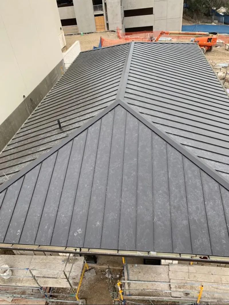 Commercial metal roof construction with crane equipment in Tucson Estates